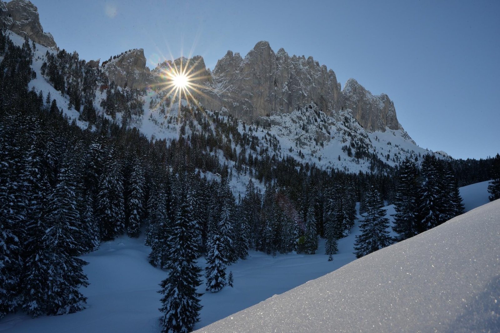 Sunburst over snow-covered peaks