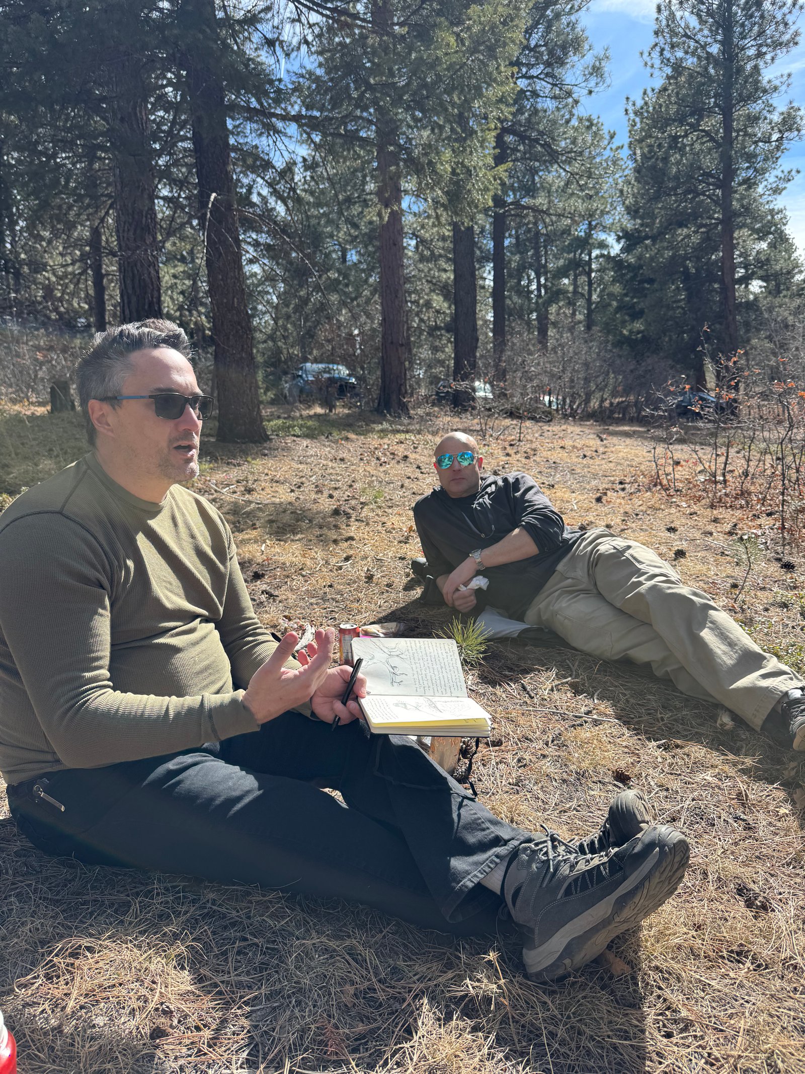 Two archers resting and sketching in the forest